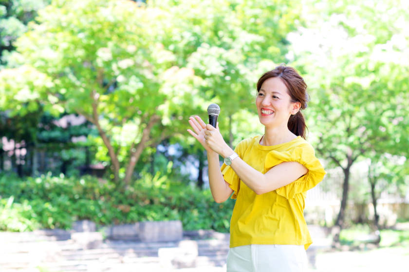 写真:拍手をしながら進行を務めるイベントMC