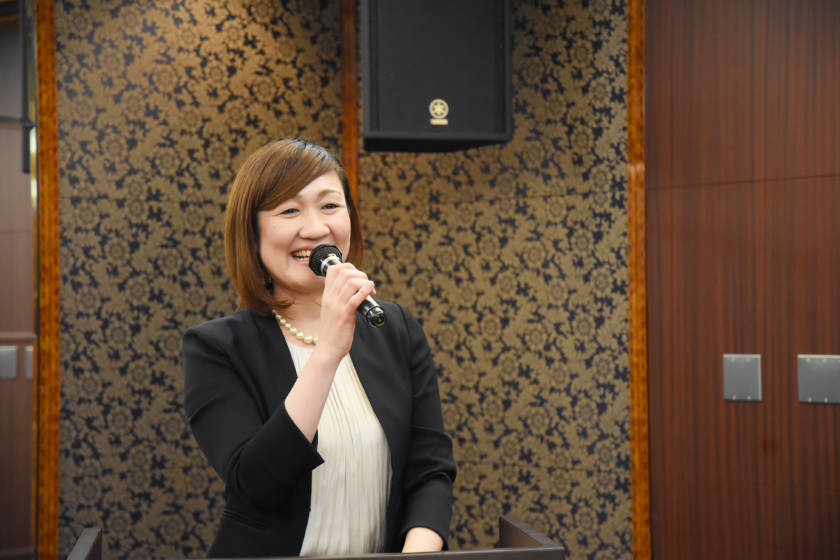 写真:マイクで話している笑顔のMC
